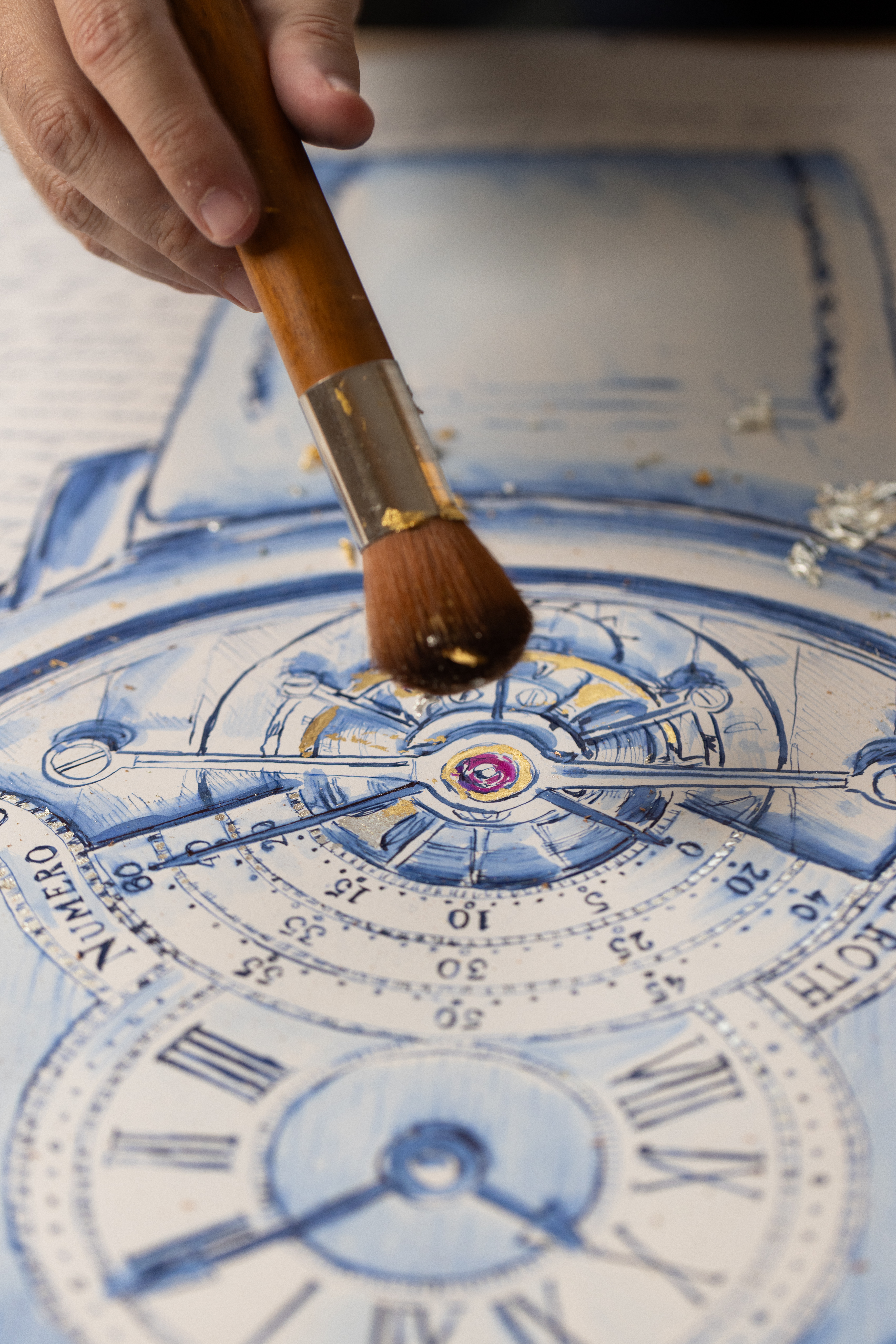 A soft brush finishing gold-leaf details on the tourbillon artwork.