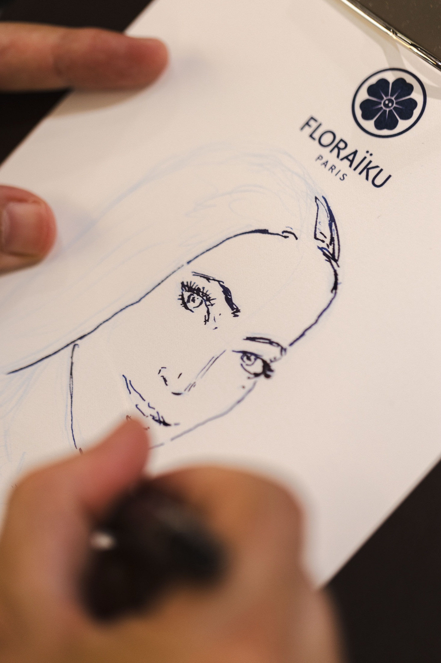 A blue-ink portrait developing during the Floraïku activation at Globus Zurich.