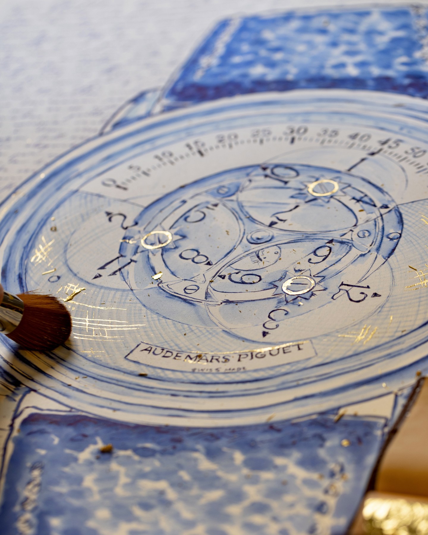 Detail of the Star Wheel drawing with gold accents on the dial and a brush at its edge.