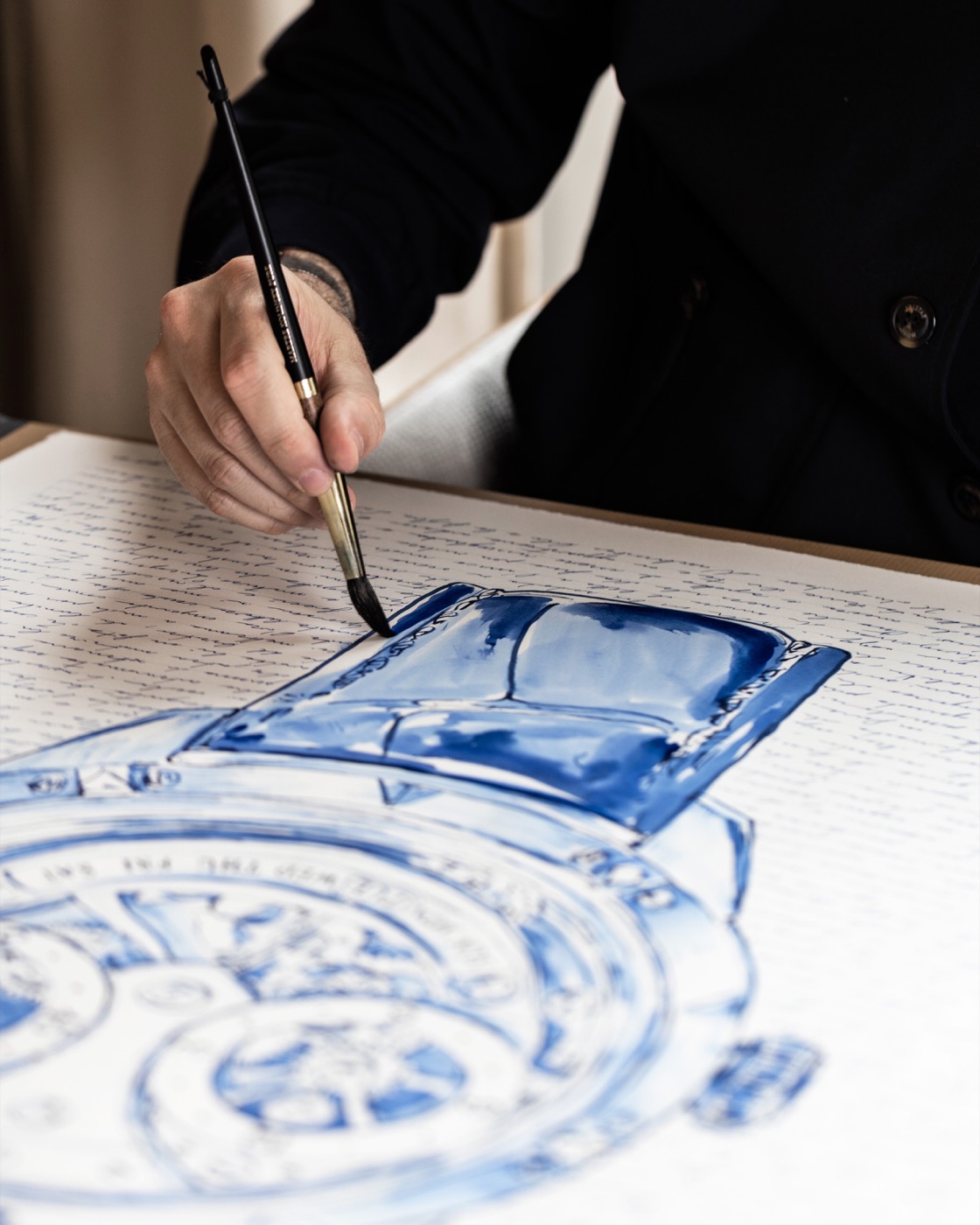 A brush painting the watch strap in blue ink.