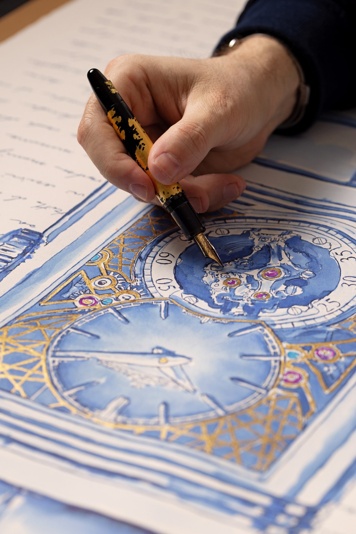 Fountain pen touching the blue-ink watch drawing, with gold details and handwriting around it.