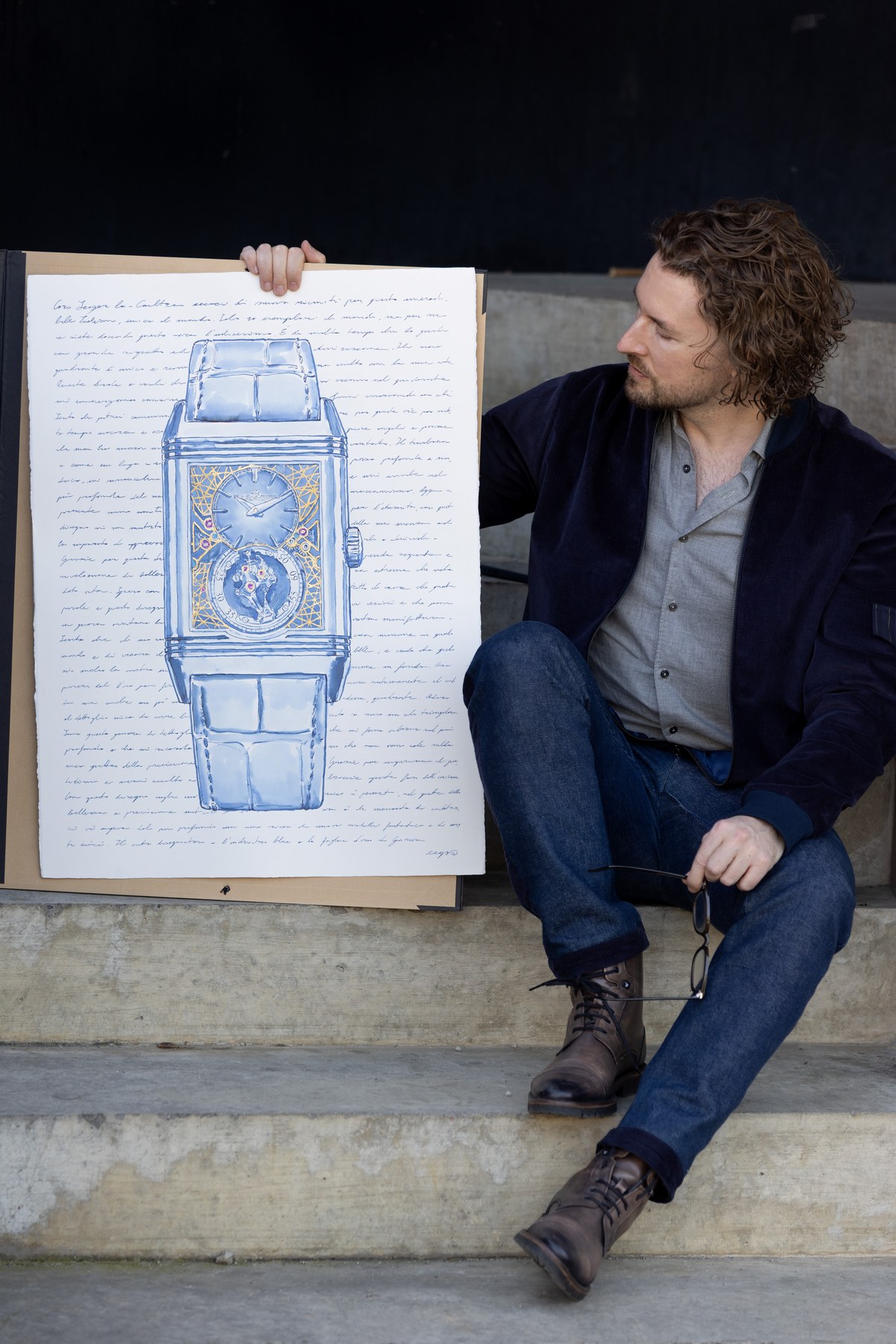 Mauro Carraro seated beside the Reverso Hybris Artistica drawing on paper.