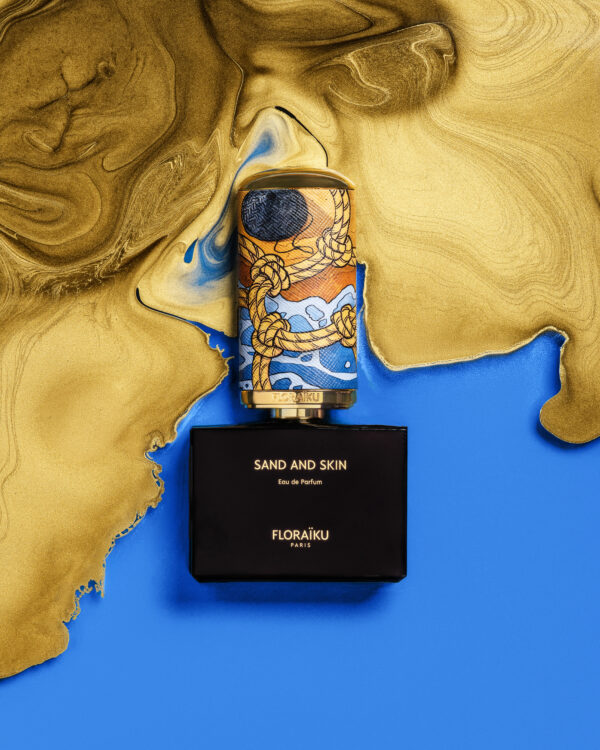 Floraïku Sand and Skin bottle and case with Mauro Carraro's cap illustration, set in blue and liquid gold.