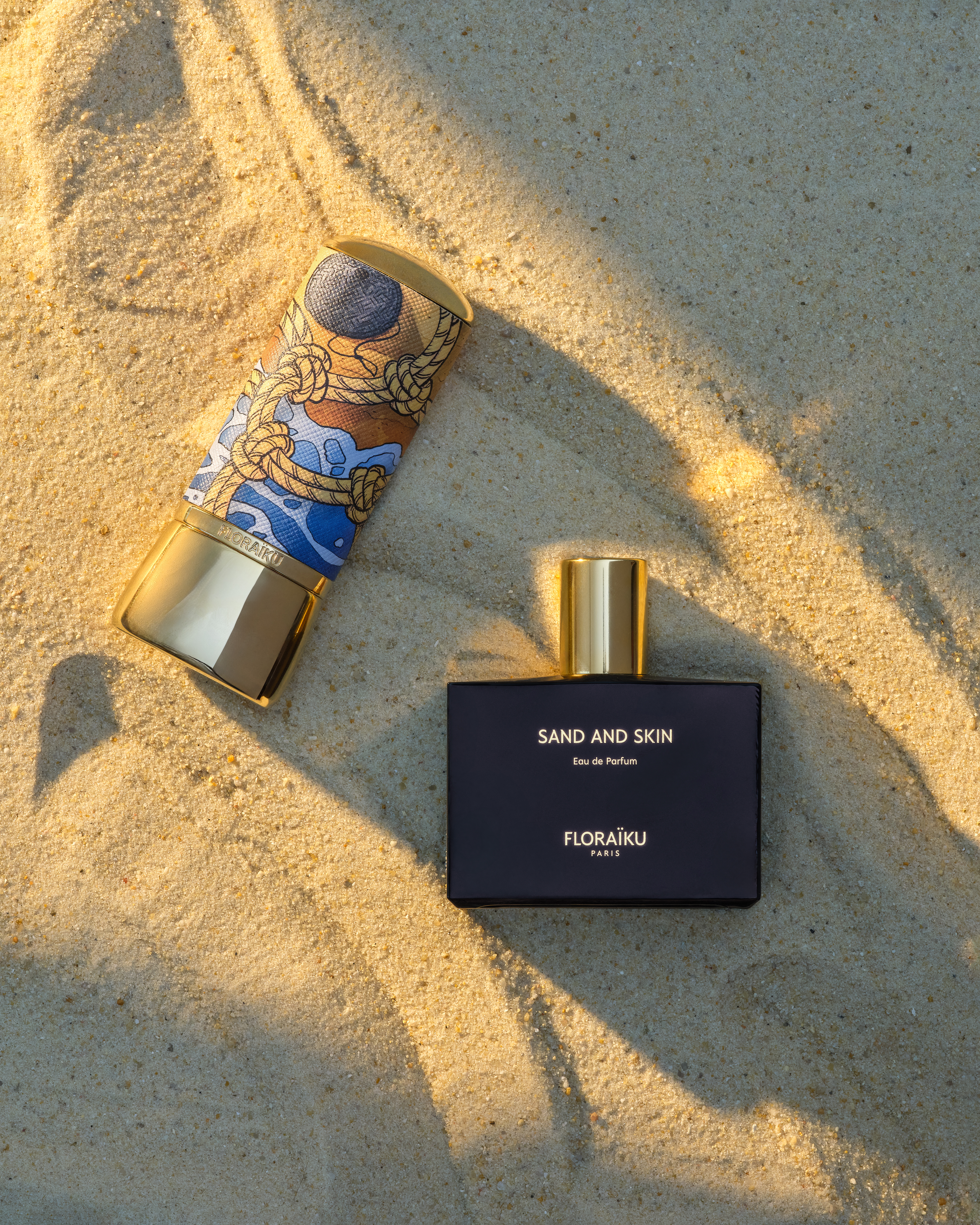 Floraïku Sand and Skin limited-edition bottle and presentation case on sand.
