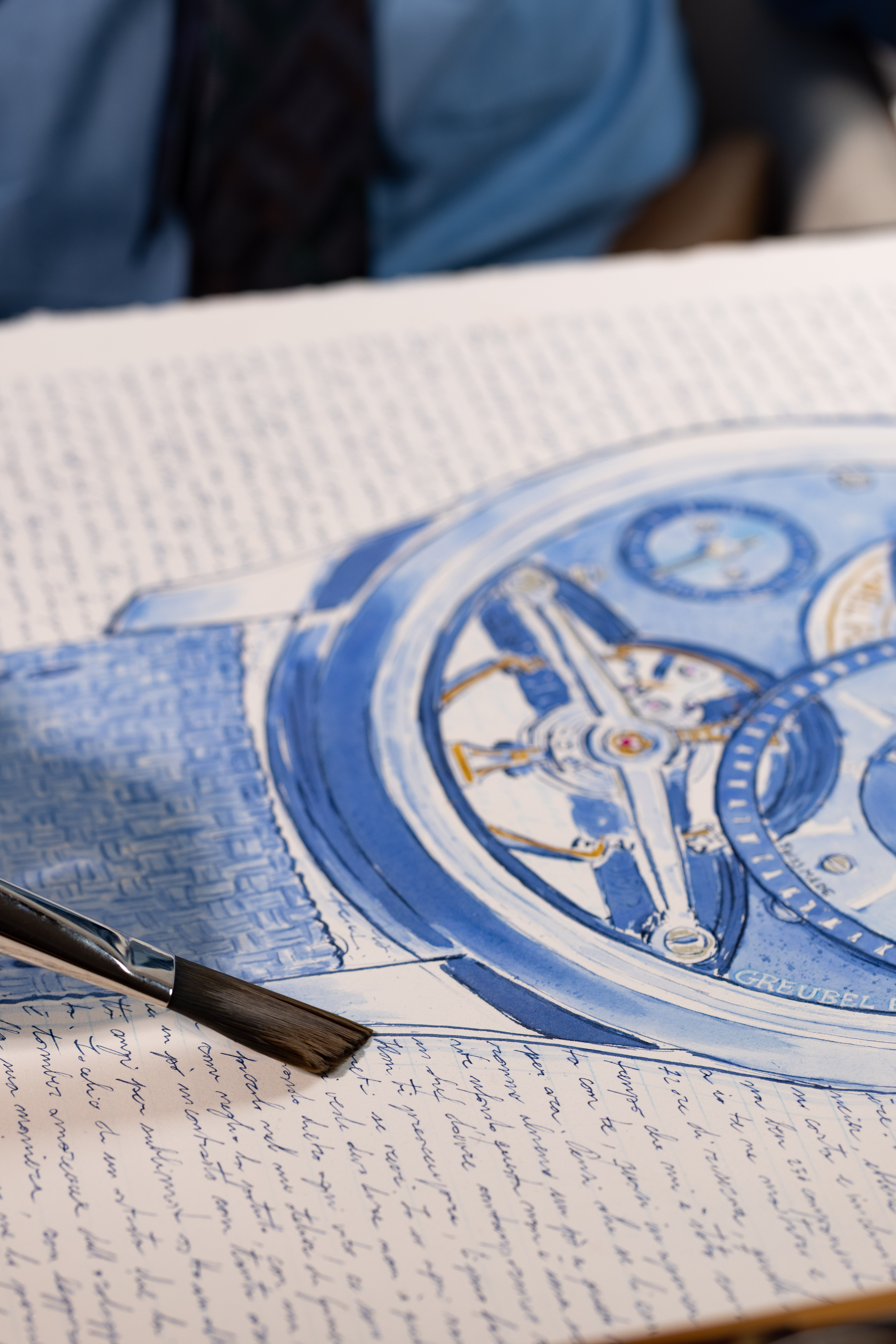 A brush beside the blue-ink watch study.