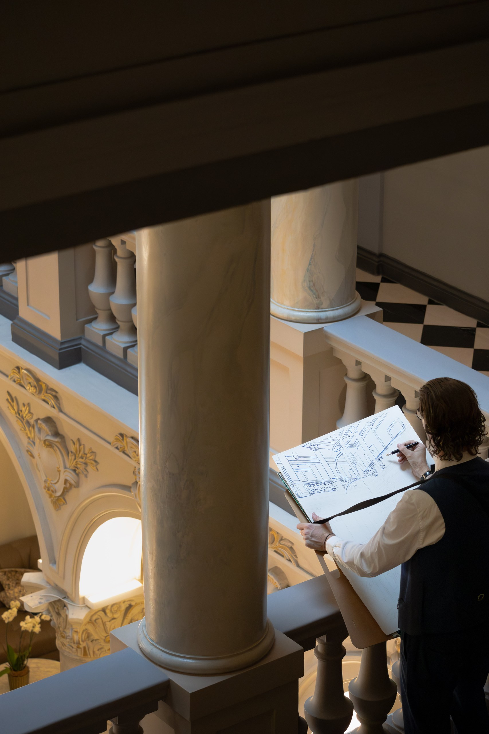 Mauro Carraro drawing beside the balustrade at The Ritz-Carlton Geneva.