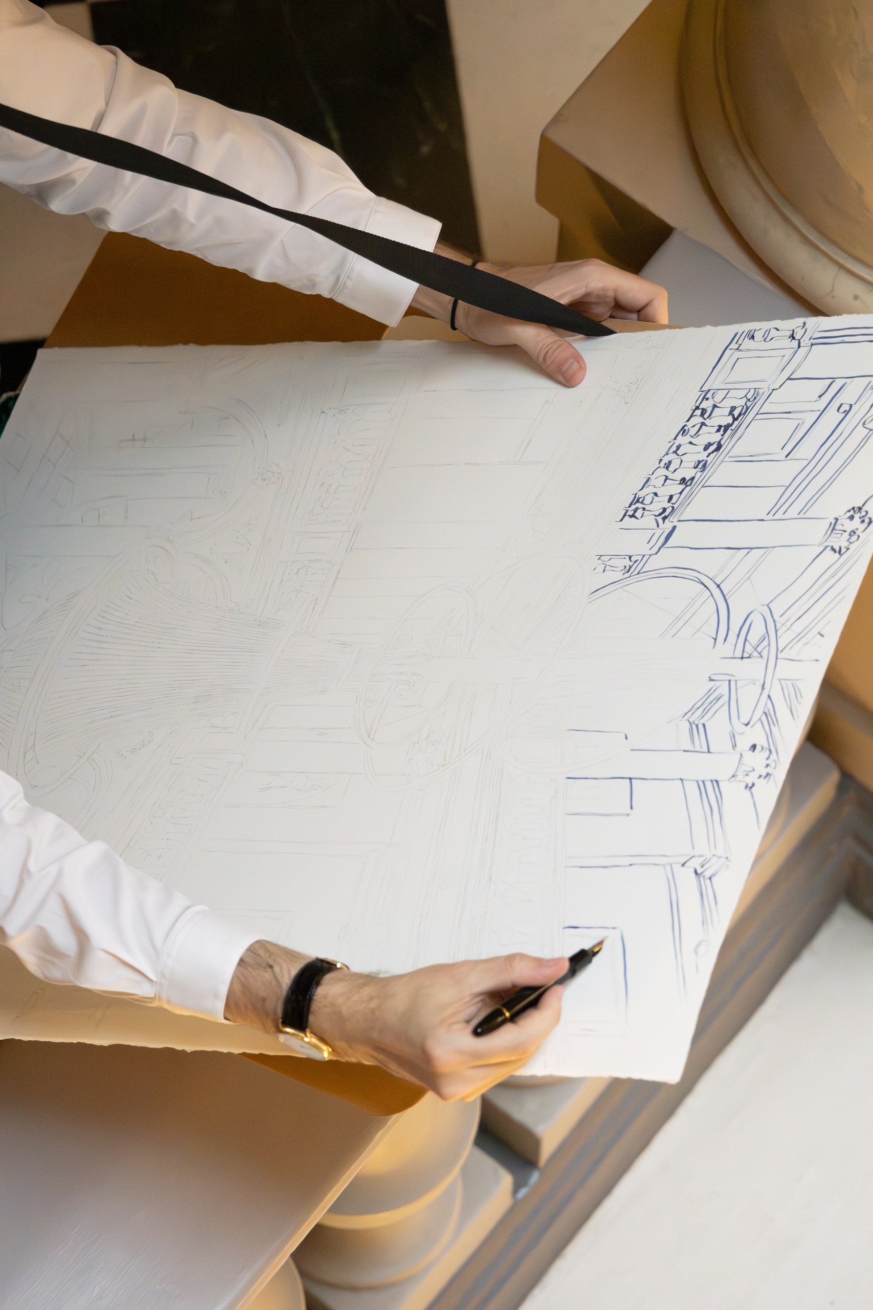 Mauro Carraro drawing architectural details on the chandelier sketch.