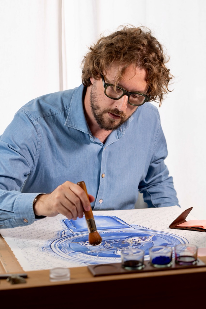 Mauro at his worktable applying leaf to the artwork.