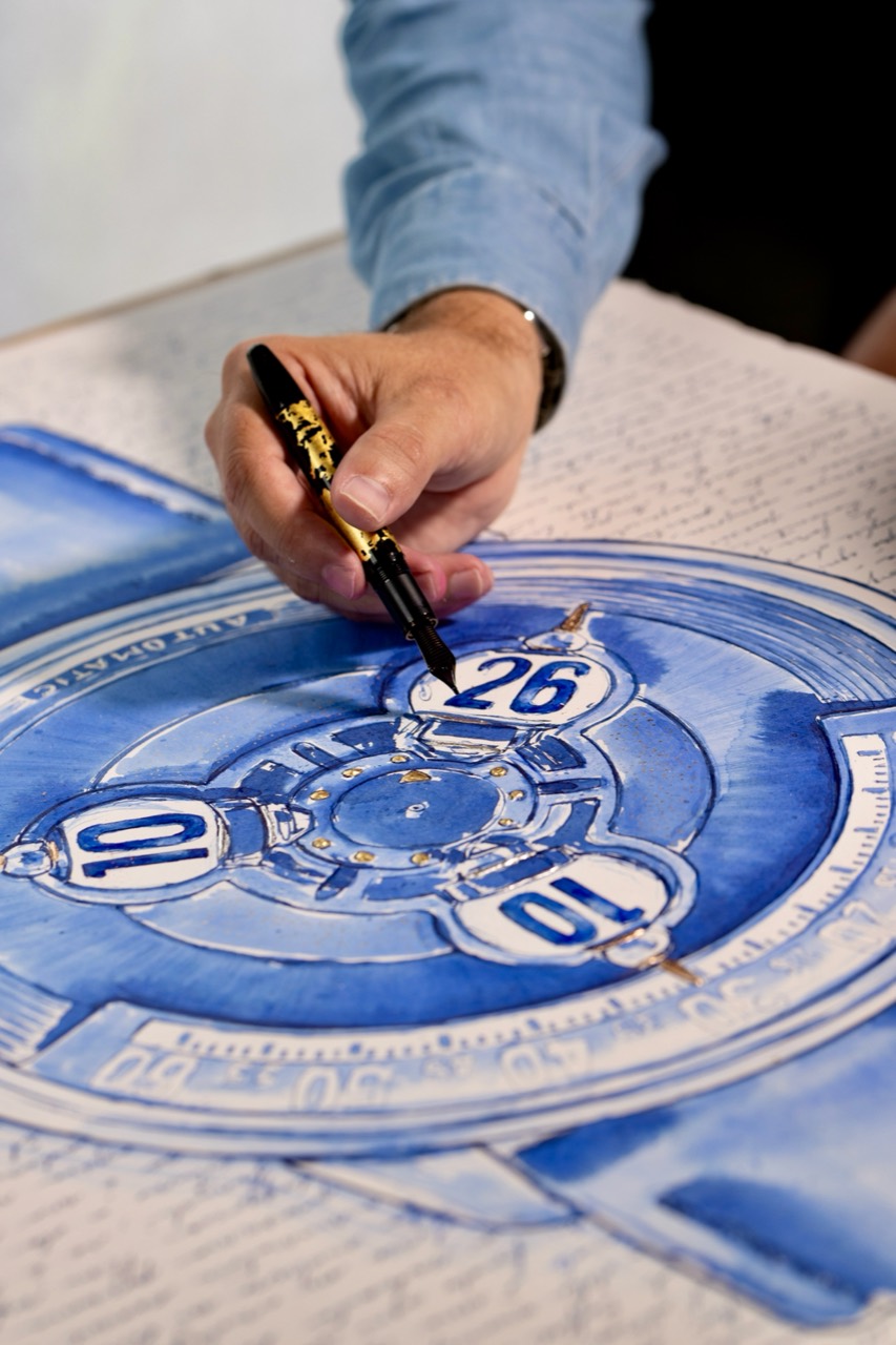 Mauro drawing with a fountain pen on the watch composition.